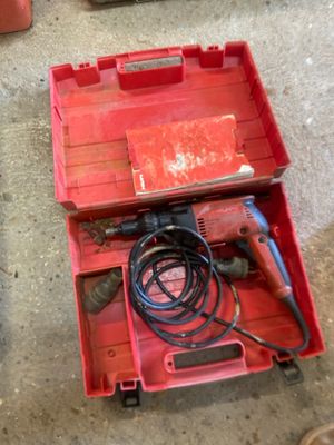 a red tool box with a drill in it on the floor