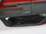 a close up of a red and black vacuum on a white surface