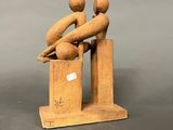 wooden figurine of two people sitting on top of a box