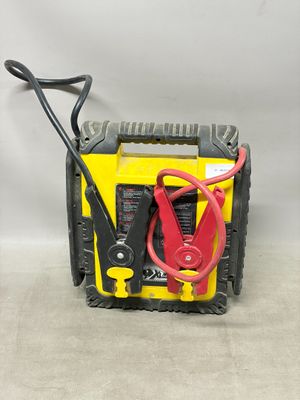 une image représentant un chargeur de batterie jaune et noir muni d'un câble de démarrage rouge et noir