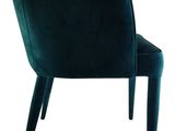 the back of a green velvet chair with wooden legs