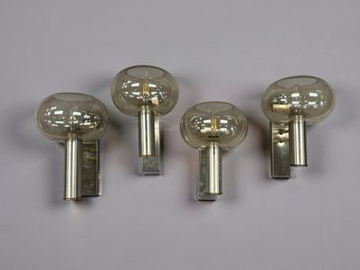 On voit trois boutons de porte en verre posés sur une surface blanche