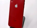 a red iphone sitting on a stand on a white surface