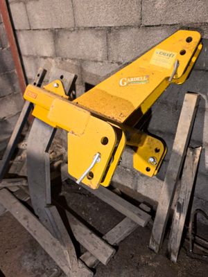 a yellow machine that is sitting on a pallet next to a brick wall
