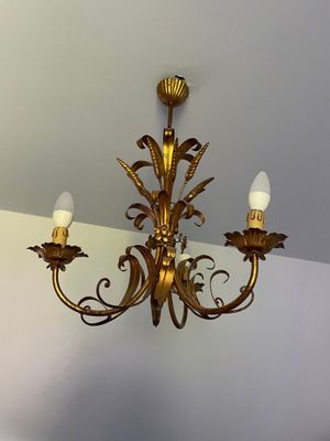 a gold chandelier hanging from the ceiling in a room