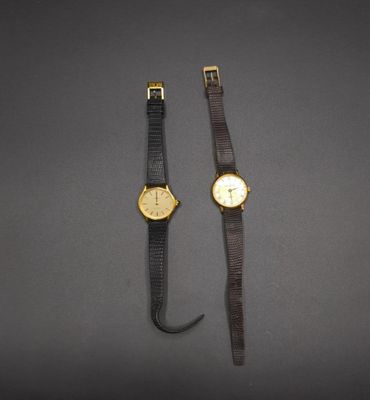 a couple of watches sitting next to each other on top of a table