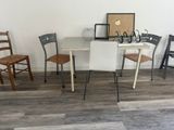 several chairs and a table in a room with a picture on the wall