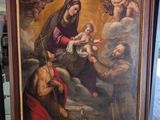 une image représentant un tableau où l'on voit un homme tenant un bébé dans une pièce