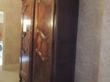 une grande armoire en bois dans le coin d'une pièce