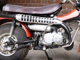 a red motorcycle parked in front of a brick wall