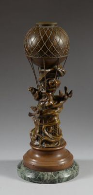 statue en bronze représentant un garçon avec une montgolfière, posée sur un socle en marbre