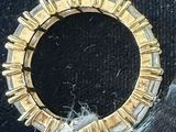 an image of a gold and diamond ring on a black surface