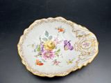 a small plate with flowers on it sitting on a table