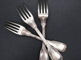 three forks and two spoons on a black surface