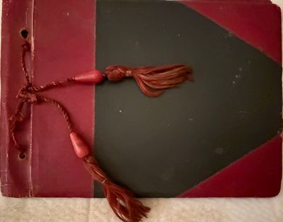 an old book with a tassel on top of it sitting on a table