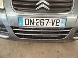 the front of a silver car with a license plate on it