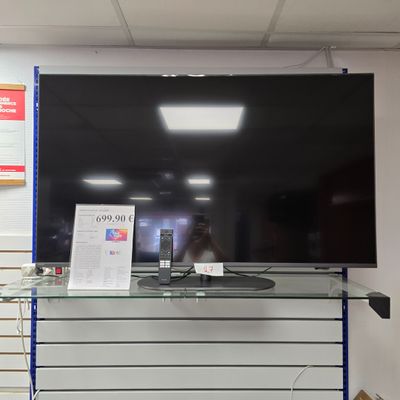 un grand téléviseur à écran plat posé sur une étagère en verre