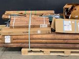 un tas de bois posé sur une palette devant un tableau noir
