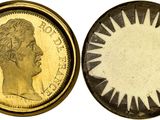 a close up of a coin with a sun on it