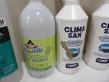 several bottles of cleaning products sit on a shelf in a bathroom