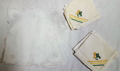 trois serviettes blanches ornées de motifs verts et jaunes