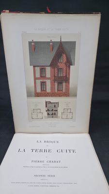 an open book with a picture of a red house on it