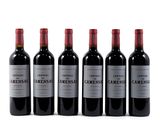 six bottles of wine are lined up in a row on a white surface