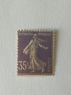 timbre violet et doré représentant une femme, sur un fond blanc