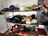 a rack of clothes in a room with a picture on the wall
