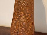 a wooden object on a wooden table with a white wall in the background