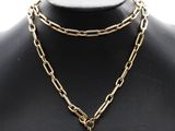 un collier composé d'une chaîne en or et d'un pendentif en pierre verte