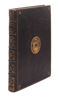 un vieux livre noir orné d'un emblème doré sur la couverture