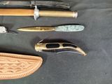 many different types of knives on a black table