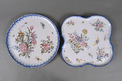 deux assiettes ornées de fleurs et de papillons, posées sur une table