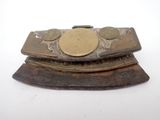 un petit objet métallique surmonté d'une pièce de monnaie