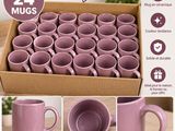 des tasses à café violettes dans une boîte, accompagnées d'instructions pour leur donner l'aspect de la poterie