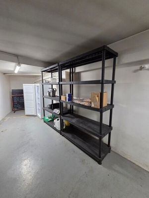 a room with a shelf and a refrigerator in it