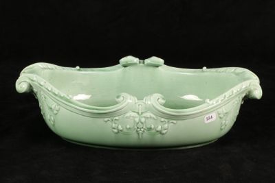 a green bowl with a handle on a black background