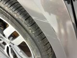 a close up of a car ' s front tire with scratches on it