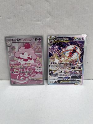 two pokemon cards sitting next to each other on a white surface