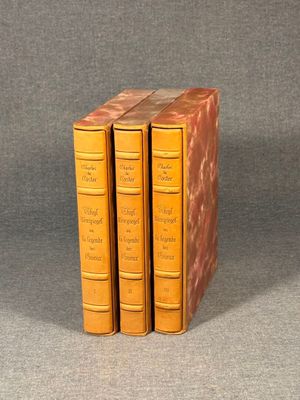 three books sitting on top of each other on a gray surface