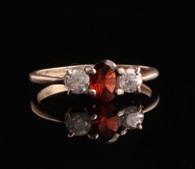 un gros plan d'une bague sertie d'un diamant rouge et blanc sur une surface noire