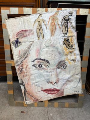 peinture représentant le visage d'une femme sur une feuille de papier posée devant une commode