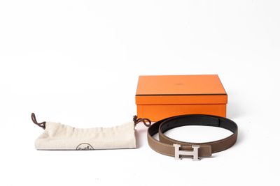 une ceinture en cuir marron avec une boucle en argent et une petite pochette