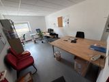 une photo d'une pièce avec un bureau et des chaises
