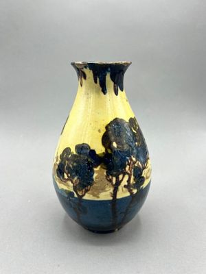 a blue and yellow vase sitting on a table