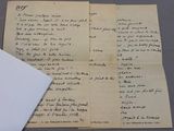 an old handwritten letter is sitting on top of a piece of paper next to a piece of paper