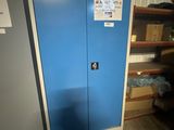 une porte bleue sur laquelle est accrochée une pancarte, dans une pièce
