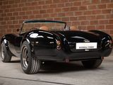 an image of a black sports car parked in front of a brick wall
