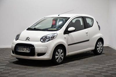 la photo d'une petite voiture blanche garée sur un sol en damier